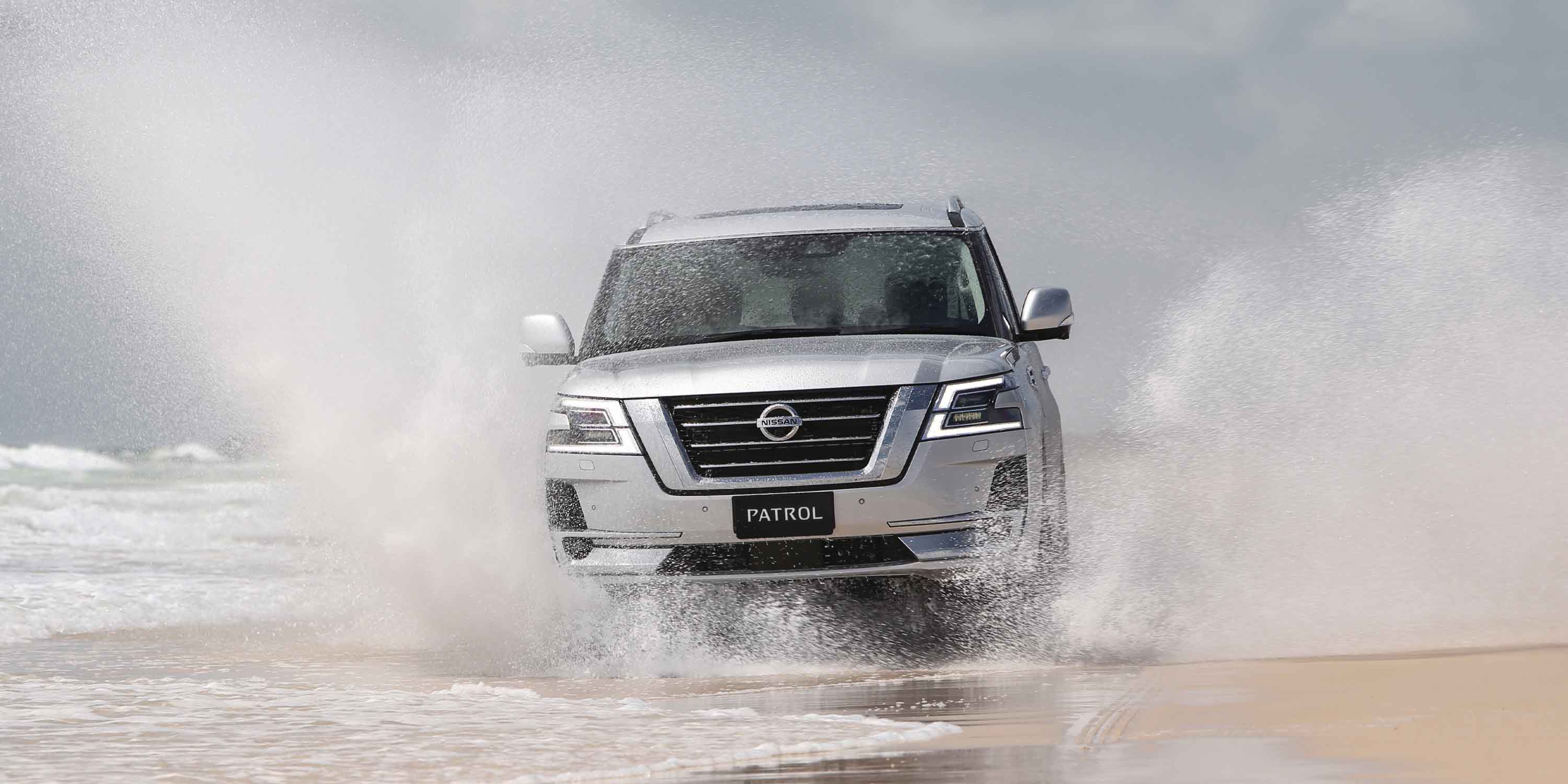 Patrol driving through wave on beach